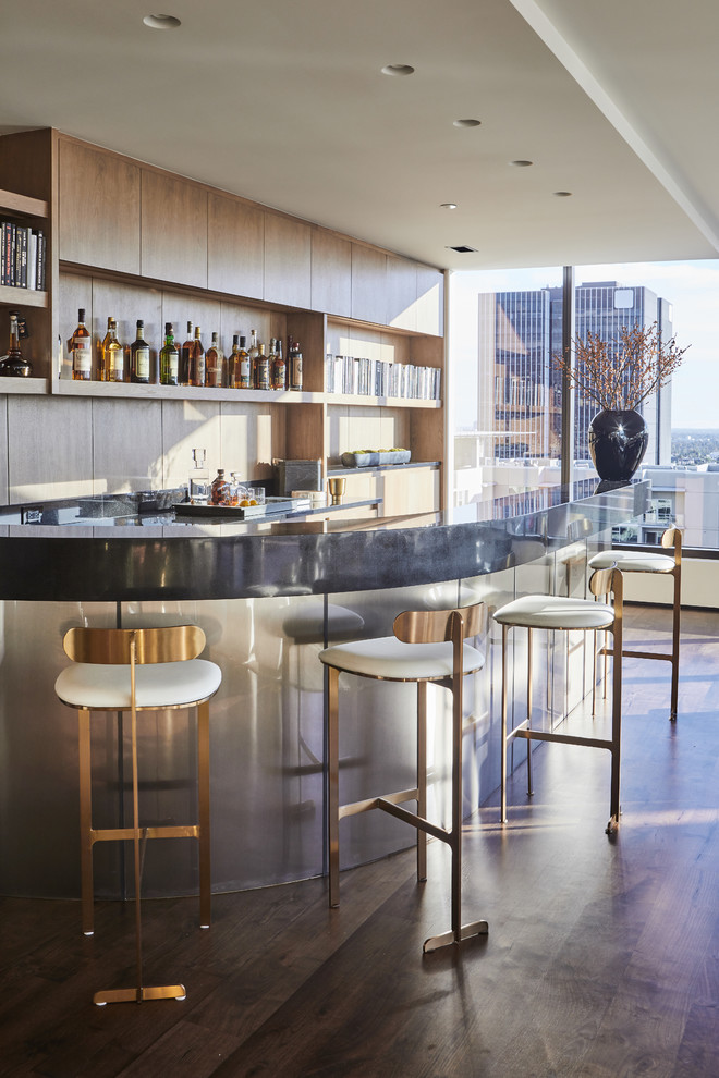 Inspiration for a contemporary galley seated home bar in Los Angeles with flat-panel cabinets, light wood cabinets, brown splashback, timber splashback, dark hardwood floors, brown floor and grey benchtop.