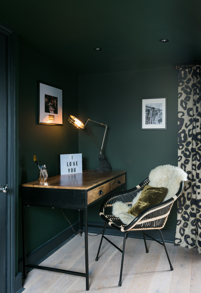 Mid-sized contemporary study room in London with green walls, light hardwood floors and a freestanding desk.