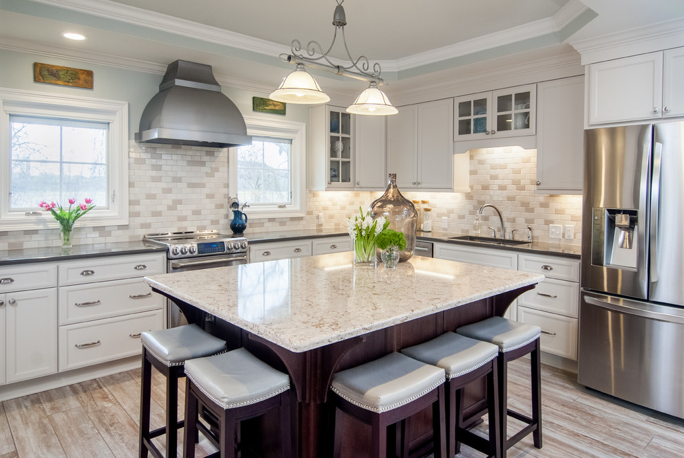 Inspiration for a large traditional u-shaped open plan kitchen in New Orleans with quartz benchtops, with island, a double-bowl sink, white cabinets, beige splashback, stainless steel appliances, porcelain floors, flat-panel cabinets, subway tile splashback, grey floor, white benchtop and recessed.