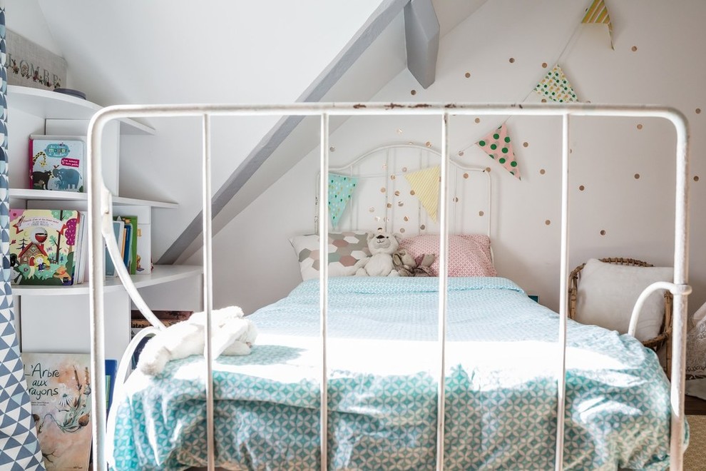 Mid-sized scandinavian gender-neutral kids' bedroom in Paris with white walls, light hardwood floors and brown floor for kids 4-10 years old.