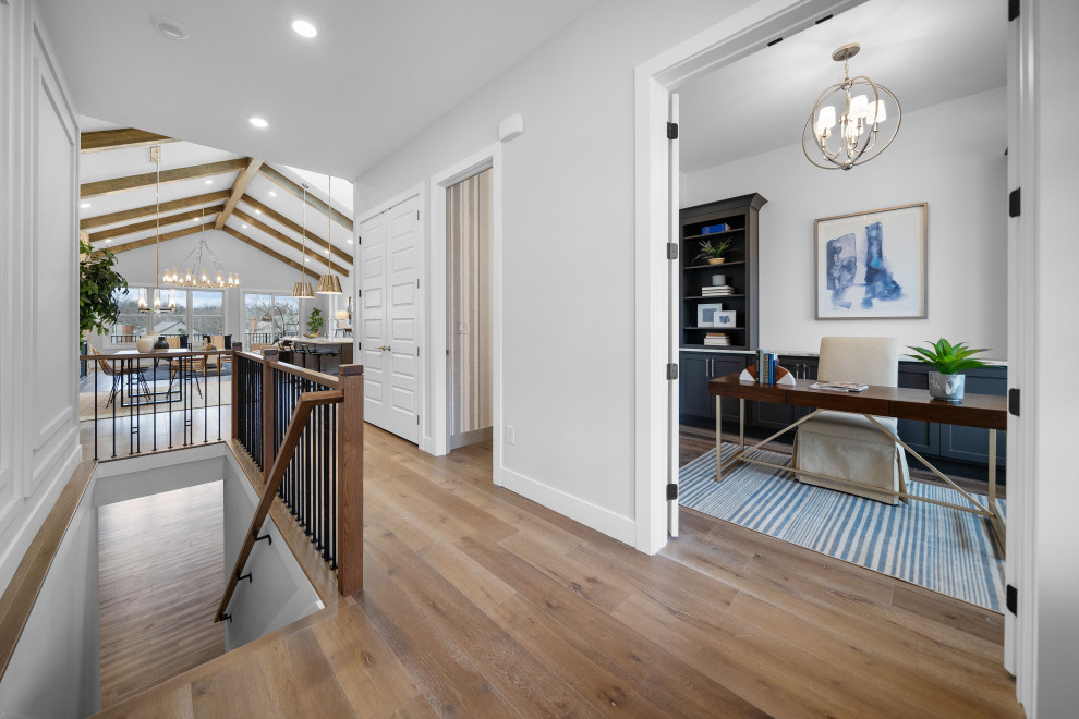 Inspiration for a transitional medium tone wood floor and wall paneling foyer remodel in Cincinnati with white walls and a brown front door