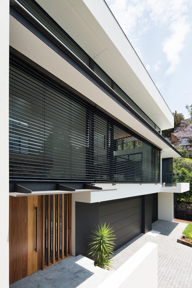 This is an example of a large contemporary three-storey exterior in Sydney with a flat roof.