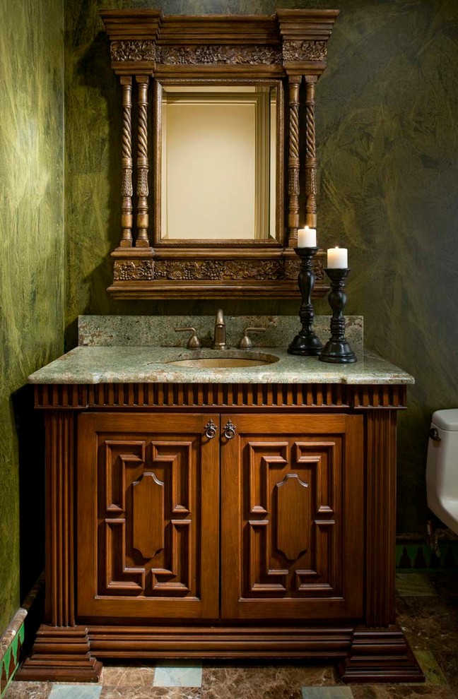 Design ideas for a mid-sized mediterranean powder room in Dallas with green walls, marble floors, an undermount sink, furniture-like cabinets, medium wood cabinets and granite benchtops.