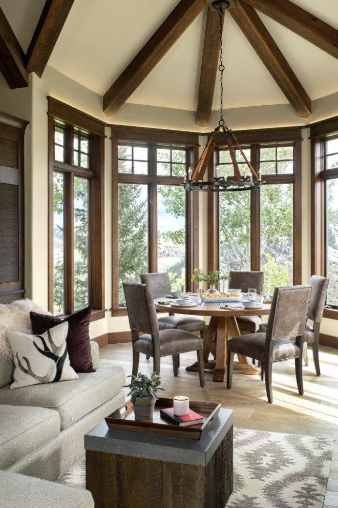Inspiration for a country dining room in Denver with beige walls, medium hardwood floors, brown floor and exposed beam.