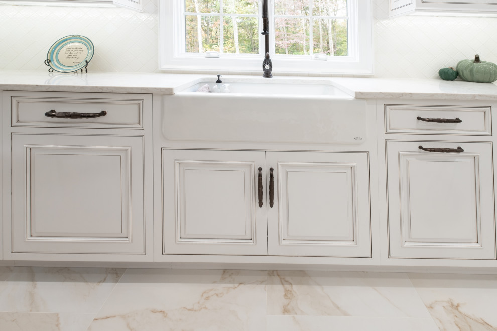 Exempel på ett mellanstort klassiskt vit vitt kök, med en rustik diskho, luckor med profilerade fronter, vita skåp, bänkskiva i kvarts, vitt stänkskydd, integrerade vitvaror, marmorgolv, en köksö och vitt golv