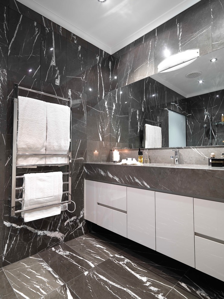 This is an example of a mid-sized contemporary master bathroom in Melbourne with an undermount sink, flat-panel cabinets, black cabinets, marble benchtops, an open shower, a wall-mount toilet, black tile, stone tile, black walls and marble floors.