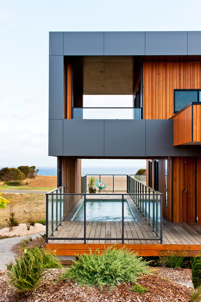 Photo of a large beach style two-storey exterior in Melbourne with wood siding.
