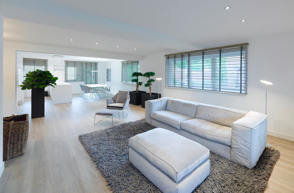 Mid-sized contemporary formal open concept living room in Stuttgart with white walls, vinyl floors, a standard fireplace, a plaster fireplace surround, beige floor and a wall-mounted tv.