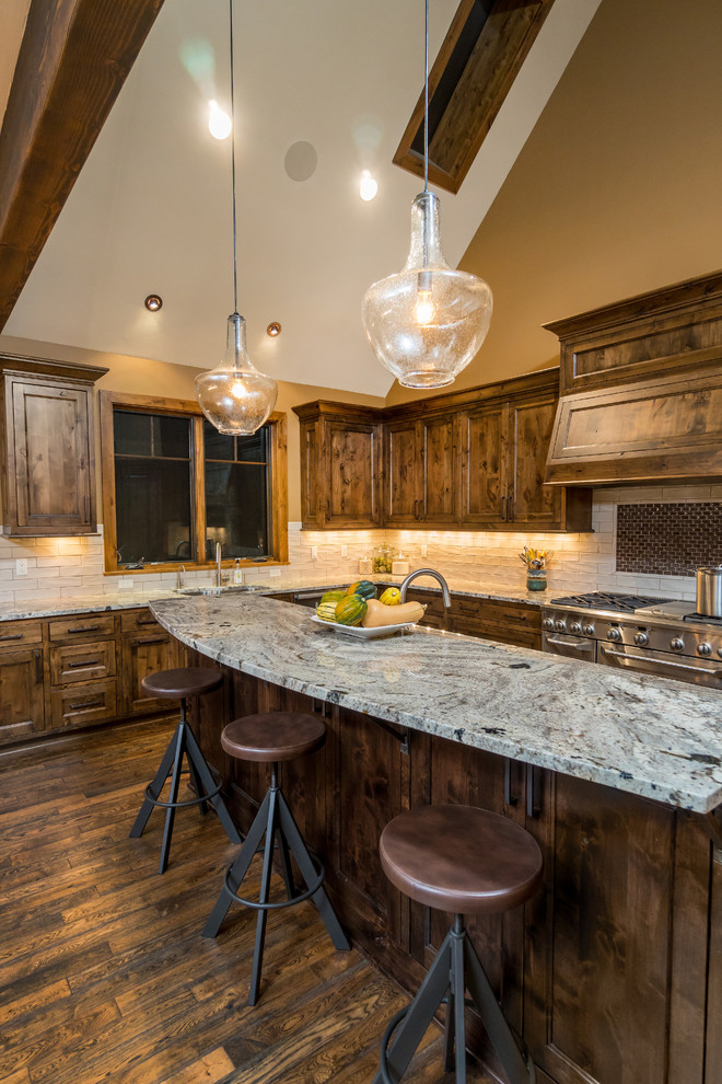 Example of a large mountain style u-shaped medium tone wood floor eat-in kitchen design with an undermount sink, beaded inset cabinets, medium tone wood cabinets, granite countertops, stone tile backsplash, stainless steel appliances and an island
