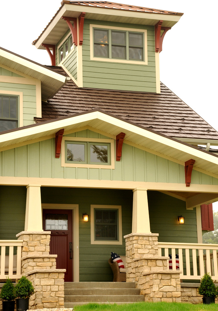 This is an example of a mid-sized arts and crafts two-storey green exterior in Other with wood siding and a gable roof.