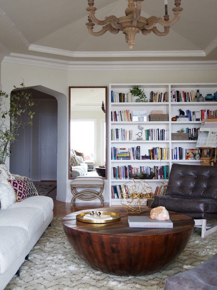 This is an example of an eclectic enclosed living room in San Francisco with a library and white walls.