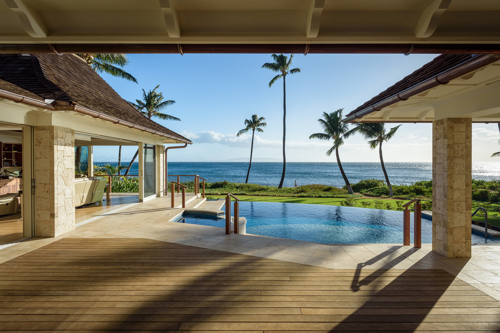 Design ideas for a beach style backyard deck in Hawaii with a roof extension.