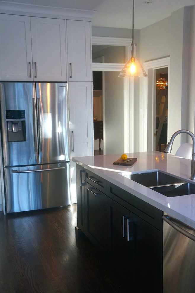 Kitchen - transitional galley dark wood floor kitchen idea in Toronto with an undermount sink, shaker cabinets, white cabinets, quartz countertops, blue backsplash, glass tile backsplash, stainless steel appliances and an island