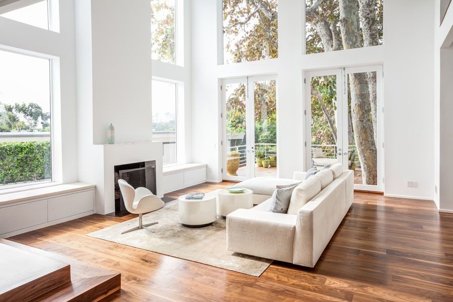 This is an example of a large modern enclosed living room in Los Angeles with white walls, medium hardwood floors, no fireplace and no tv.