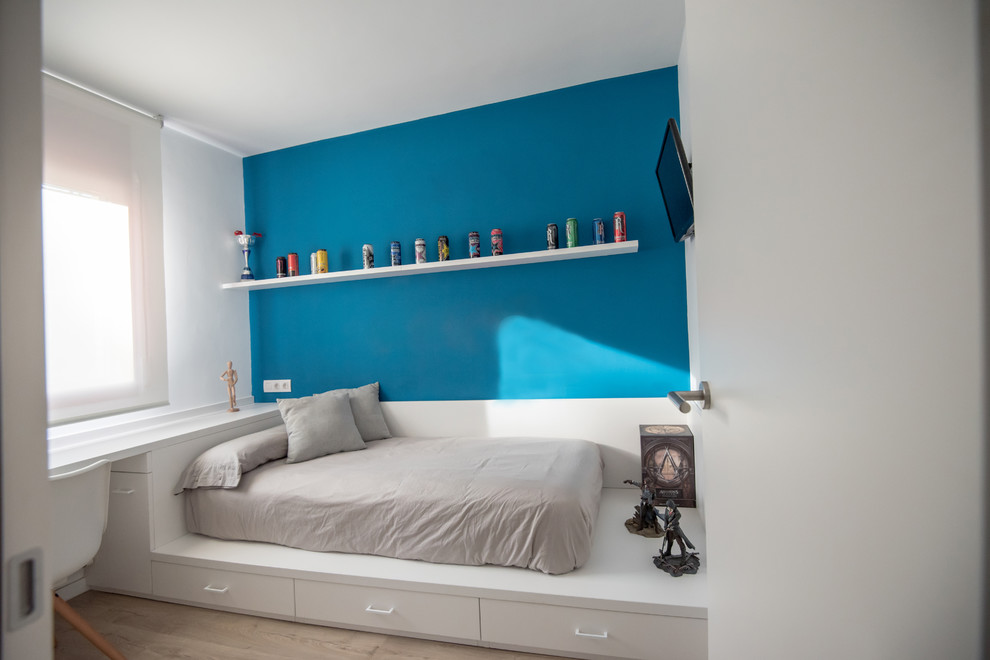 Photo of a mid-sized contemporary kids' room in Barcelona with white walls, laminate floors and brown floor.