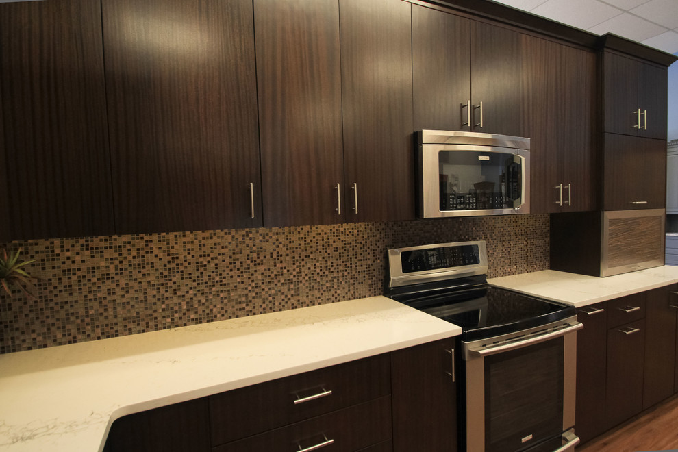 Example of a mid-sized transitional l-shaped eat-in kitchen design in Seattle with flat-panel cabinets, dark wood cabinets, granite countertops, multicolored backsplash, glass tile backsplash, stainless steel appliances and an island