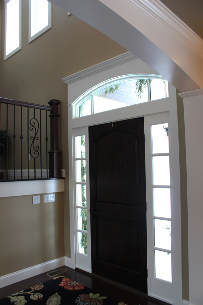 Traditional entryway in Other with beige walls, dark hardwood floors, a single front door and a dark wood front door.