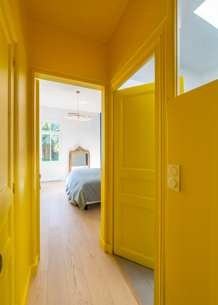 Свежая идея для дизайна: коридор в современном стиле с желтыми стенами и светлым паркетным полом - отличное фото интерьера