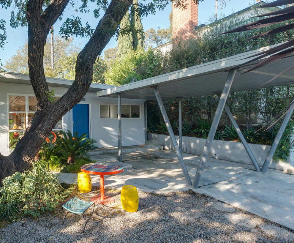 Mid-sized midcentury one-storey stucco grey exterior in Phoenix with a flat roof.