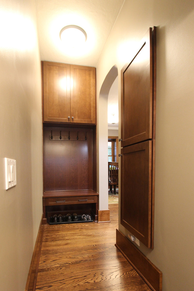 Photo of a small transitional hallway in Cleveland with yellow walls, medium hardwood floors and brown floor.