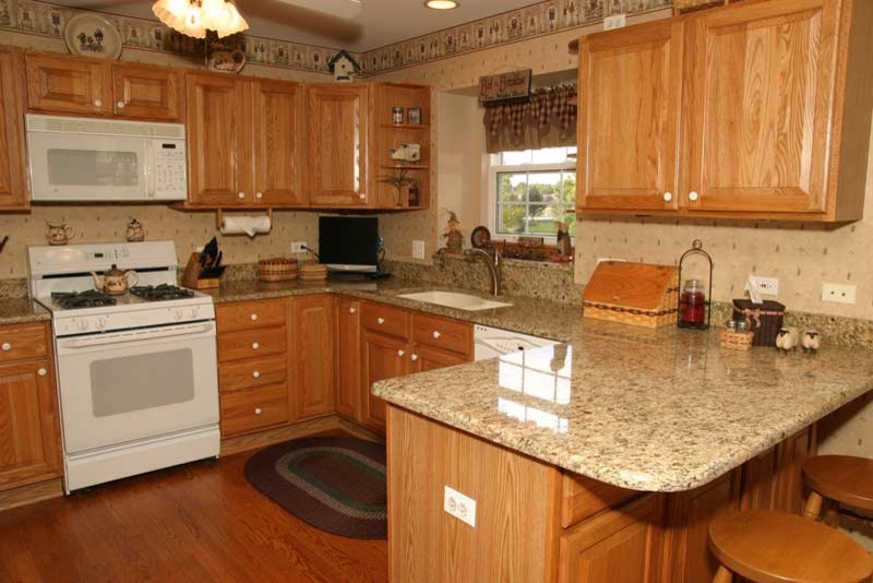 Inspiration for a transitional u-shaped medium tone wood floor kitchen pantry remodel in Chicago with raised-panel cabinets, medium tone wood cabinets and granite countertops