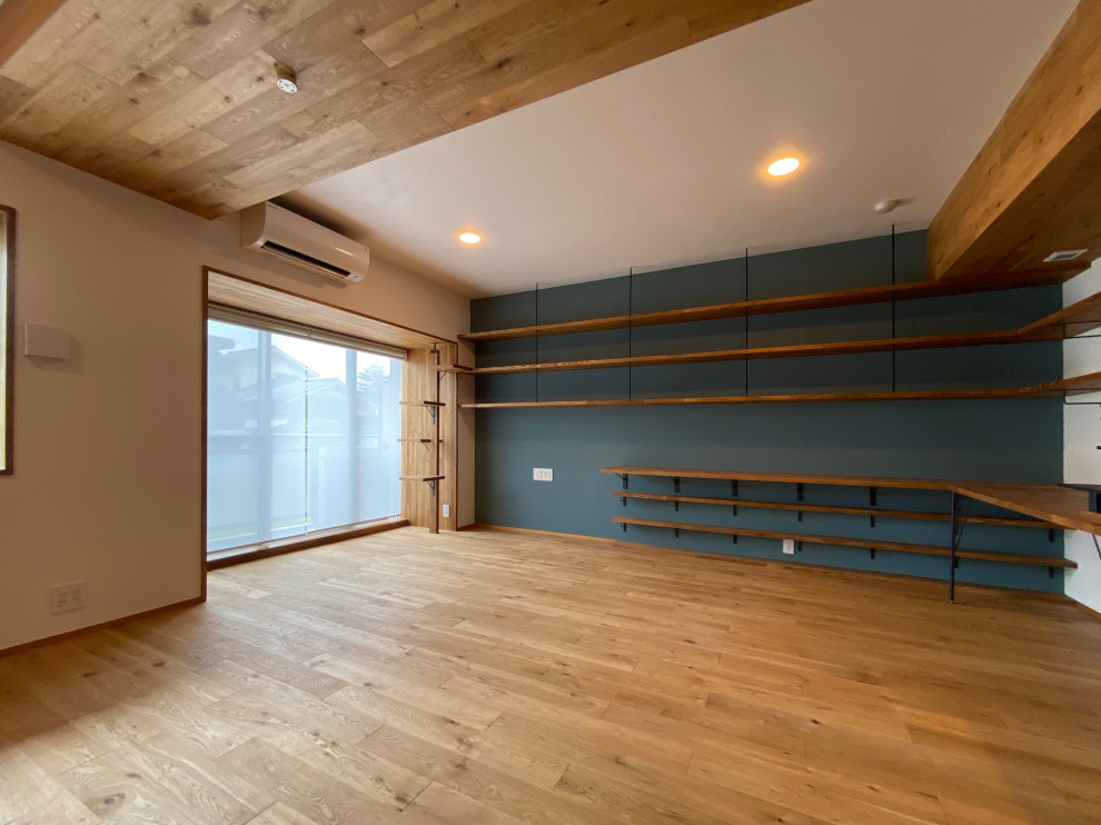 Foto di un piccolo soggiorno rustico con libreria, pareti blu, pavimento in legno massello medio, TV autoportante, pavimento marrone e soffitto in legno