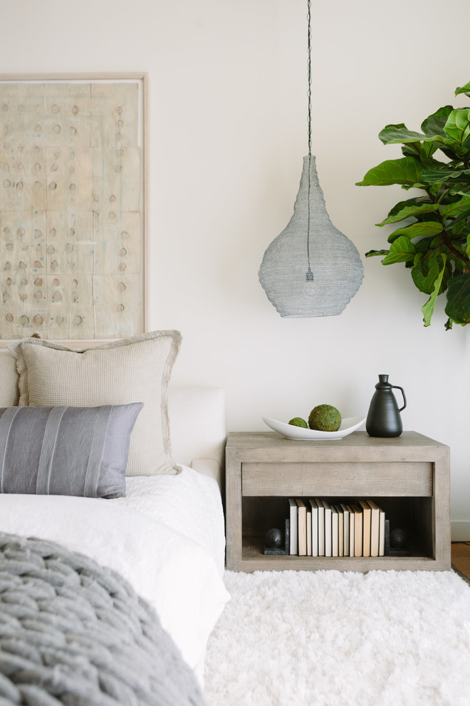 Bedroom - coastal master light wood floor bedroom idea in Nashville with white walls