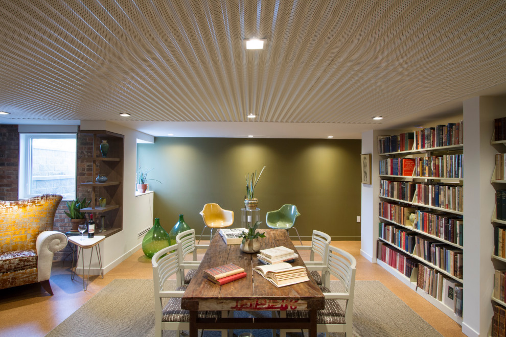 Ejemplo de sala de estar con biblioteca abierta retro de tamaño medio con paredes verdes, suelo de corcho, todas las chimeneas, marco de chimenea de ladrillo y suelo marrón