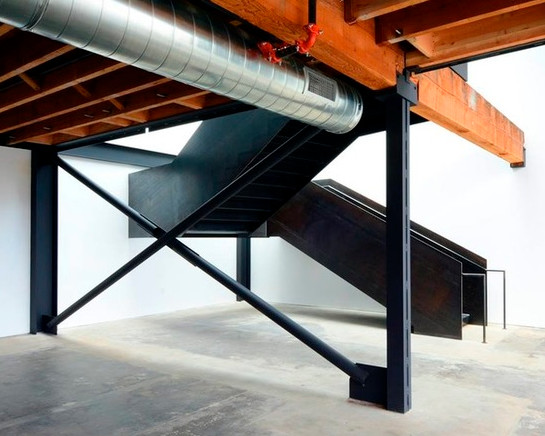 Photo of a large industrial metal u-shaped staircase in Seattle with metal risers and metal railing.