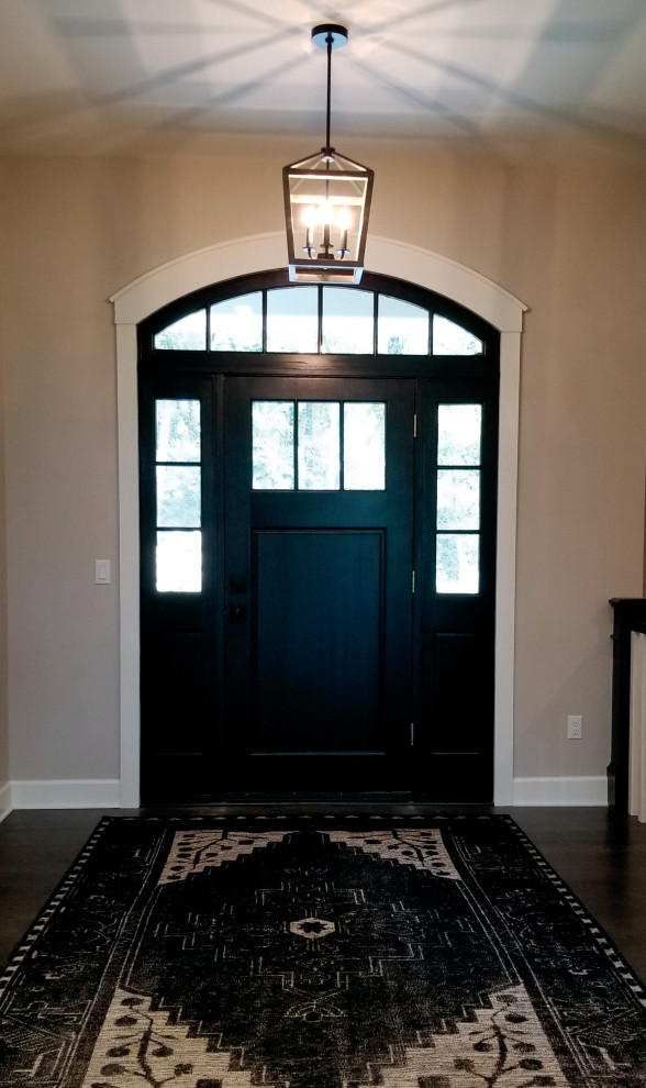 Design ideas for a large transitional front door in Milwaukee with grey walls, dark hardwood floors, a single front door, a black front door and brown floor.