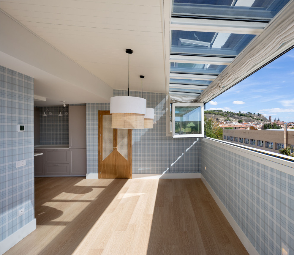 Ejemplo de comedor de cocina clásico renovado grande sin chimenea con paredes azules, suelo laminado, suelo marrón y papel pintado