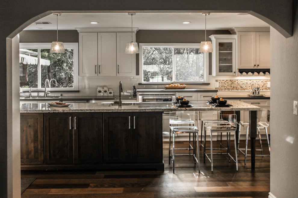 Inspiration for a large traditional u-shaped separate kitchen in San Francisco with an undermount sink, shaker cabinets, white cabinets, granite benchtops, beige splashback, mosaic tile splashback, stainless steel appliances, medium hardwood floors and with island.