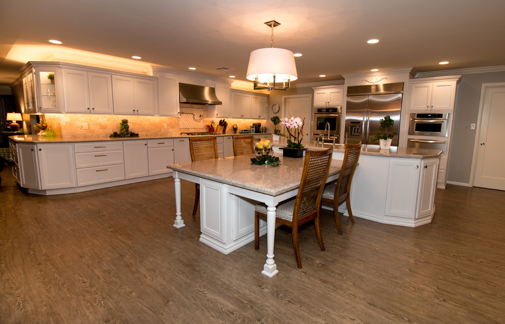 Example of a huge transitional open concept kitchen design with a farmhouse sink, recessed-panel cabinets, white cabinets, quartz countertops, beige backsplash, stone tile backsplash, stainless steel appliances and an island