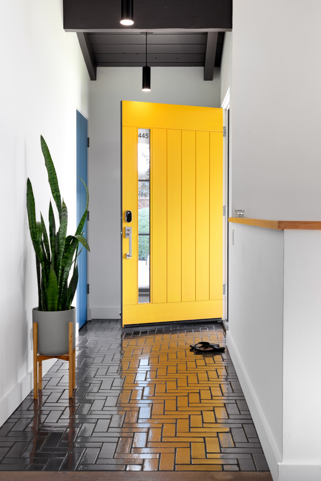Inspiration for a medium sized retro foyer in Other with white walls, ceramic flooring, a single front door, a yellow front door, black floors and a vaulted ceiling.