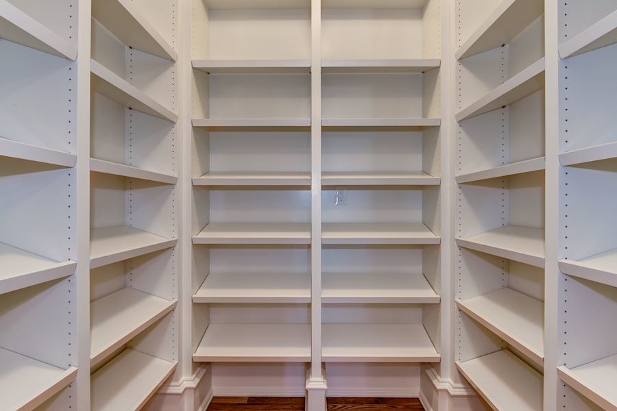 Design ideas for a large transitional gender-neutral walk-in wardrobe in DC Metro with shaker cabinets, white cabinets, light hardwood floors and beige floor.