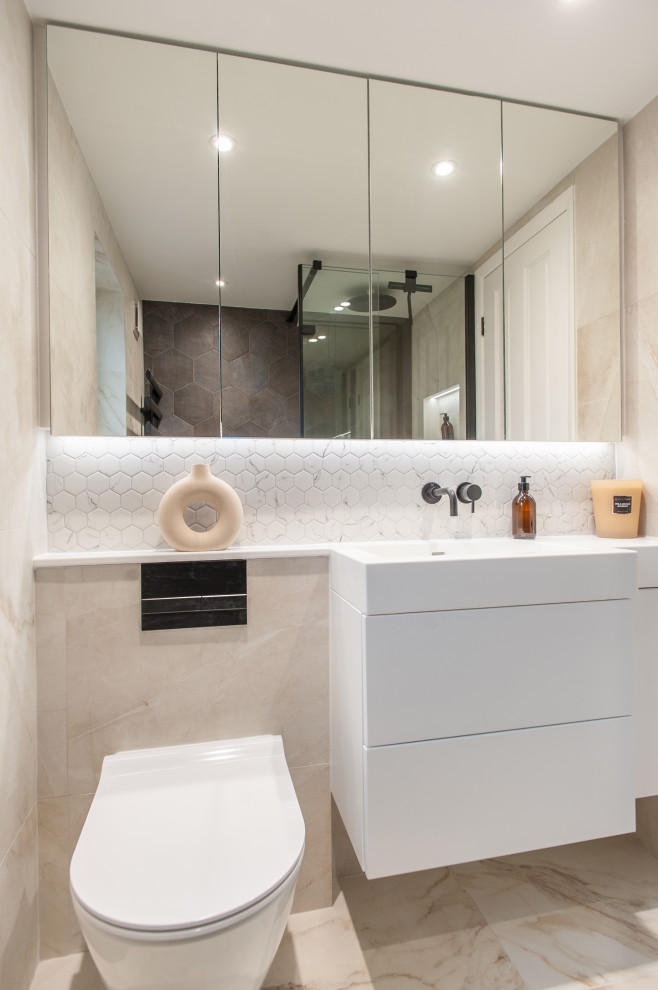 This is an example of a small contemporary grey and white ensuite bathroom in London with flat-panel cabinets, white cabinets, a walk-in shower, a wall mounted toilet, multi-coloured tiles, ceramic tiles, porcelain flooring, a built-in sink, solid surface worktops, an open shower, white worktops, a wall niche, a single sink and a floating vanity unit.