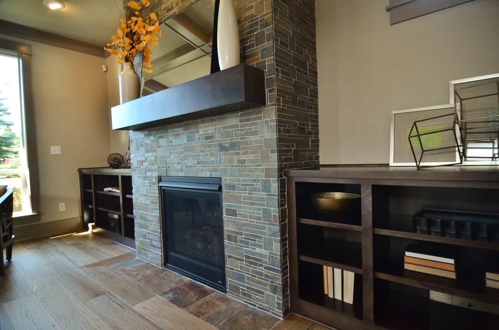 Photo of a mid-sized contemporary open concept family room in Portland with beige walls, medium hardwood floors, a tile fireplace surround and no tv.