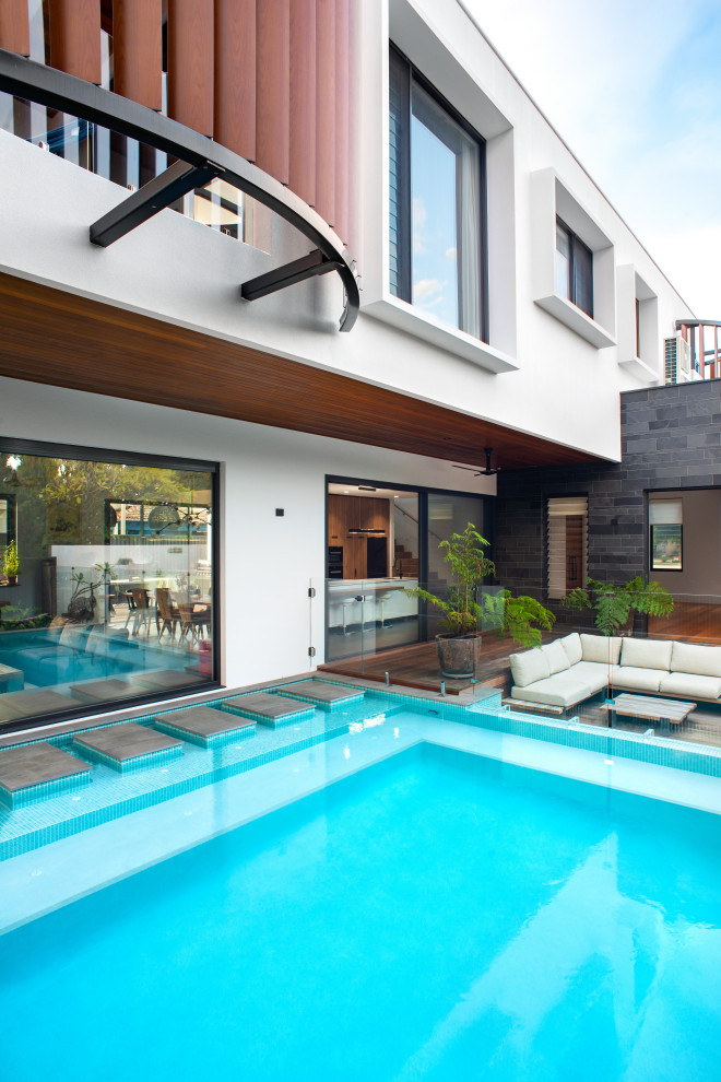 Inspiration for a large contemporary two-storey grey house exterior in Perth with stone veneer, a flat roof, a metal roof and a grey roof.