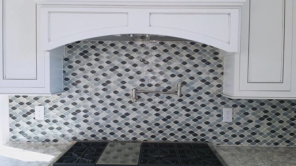 Example of a large transitional u-shaped dark wood floor eat-in kitchen design with a drop-in sink, raised-panel cabinets, white cabinets, granite countertops, blue backsplash, mosaic tile backsplash, stainless steel appliances and an island