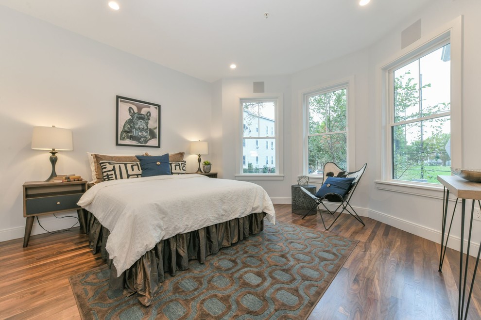 This is an example of a mid-sized contemporary bedroom in Boston with grey walls, medium hardwood floors, no fireplace and brown floor.