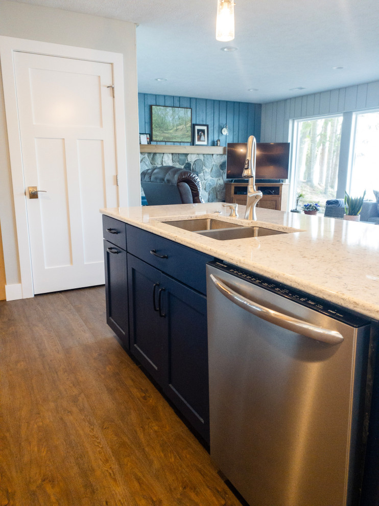 Example of a mid-sized transitional l-shaped medium tone wood floor and brown floor eat-in kitchen design with an undermount sink, flat-panel cabinets, light wood cabinets, quartz countertops, yellow backsplash, subway tile backsplash, stainless steel appliances, an island and white countertops