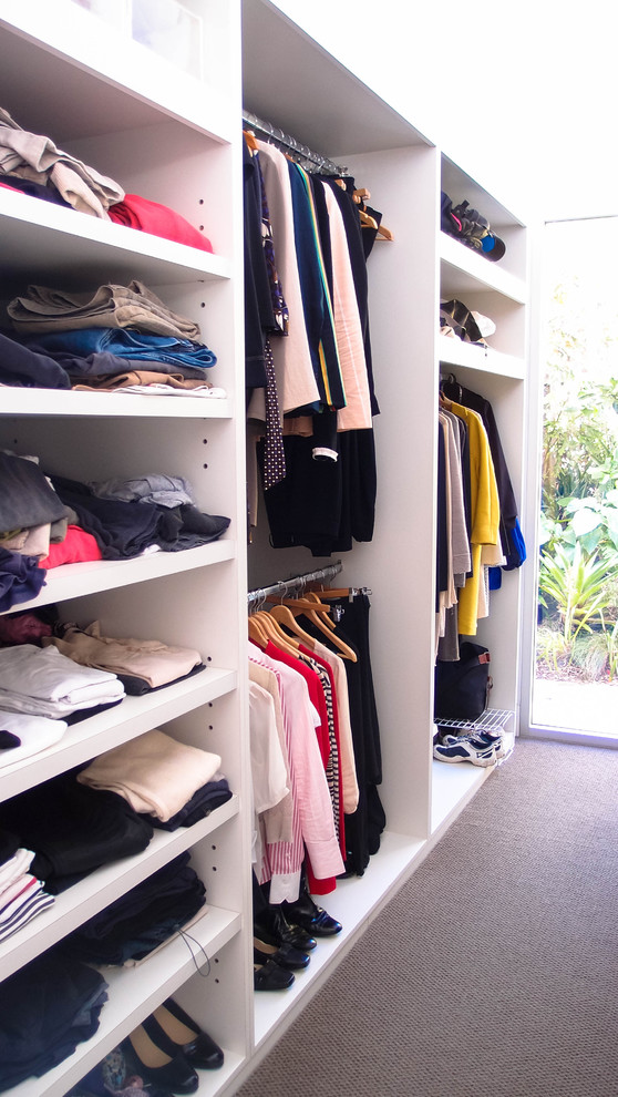 Photo of a mid-sized contemporary gender-neutral walk-in wardrobe in Sydney with open cabinets, white cabinets and carpet.