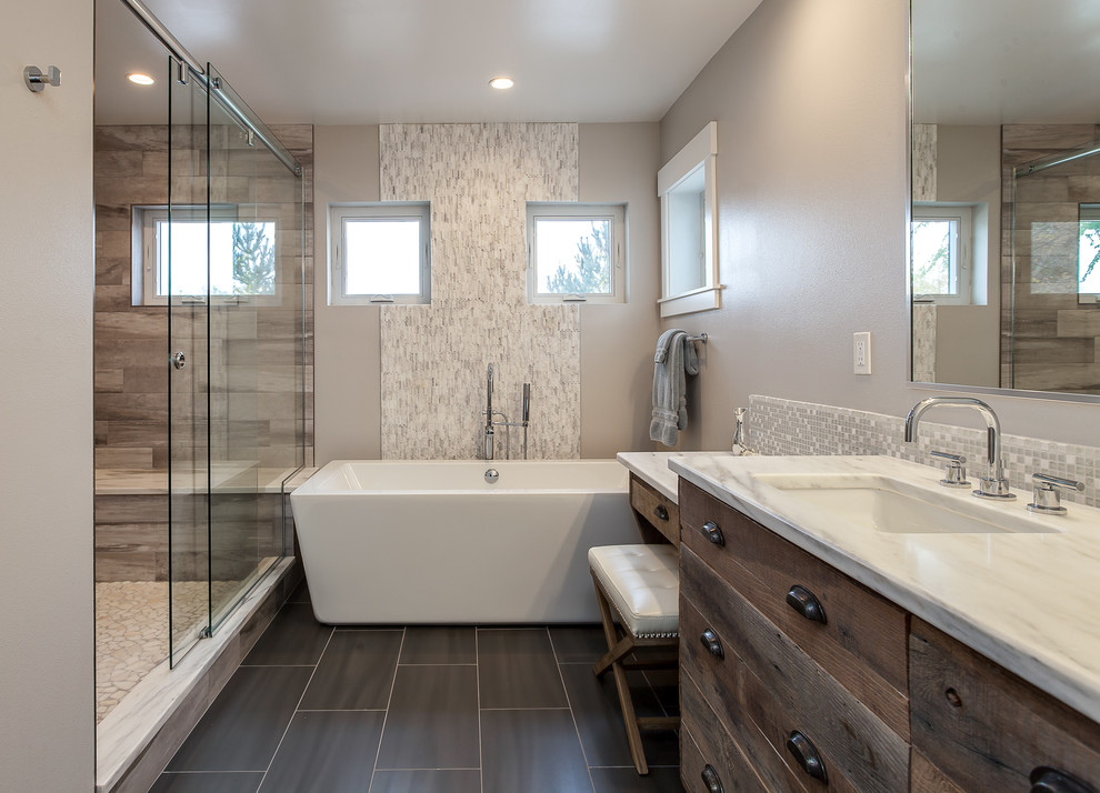 Inspiration for an expansive country master bathroom in Denver with flat-panel cabinets, distressed cabinets, a freestanding tub, an open shower, beige tile, ceramic tile, grey walls, an undermount sink and a sliding shower screen.