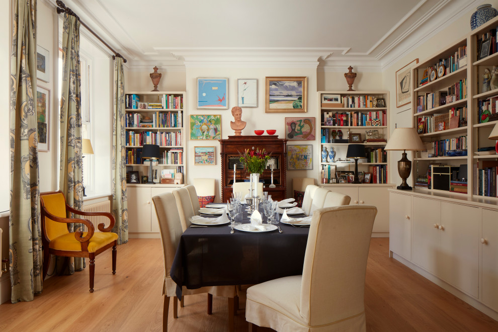 Design ideas for a medium sized eclectic enclosed dining room in London with beige walls and light hardwood flooring.
