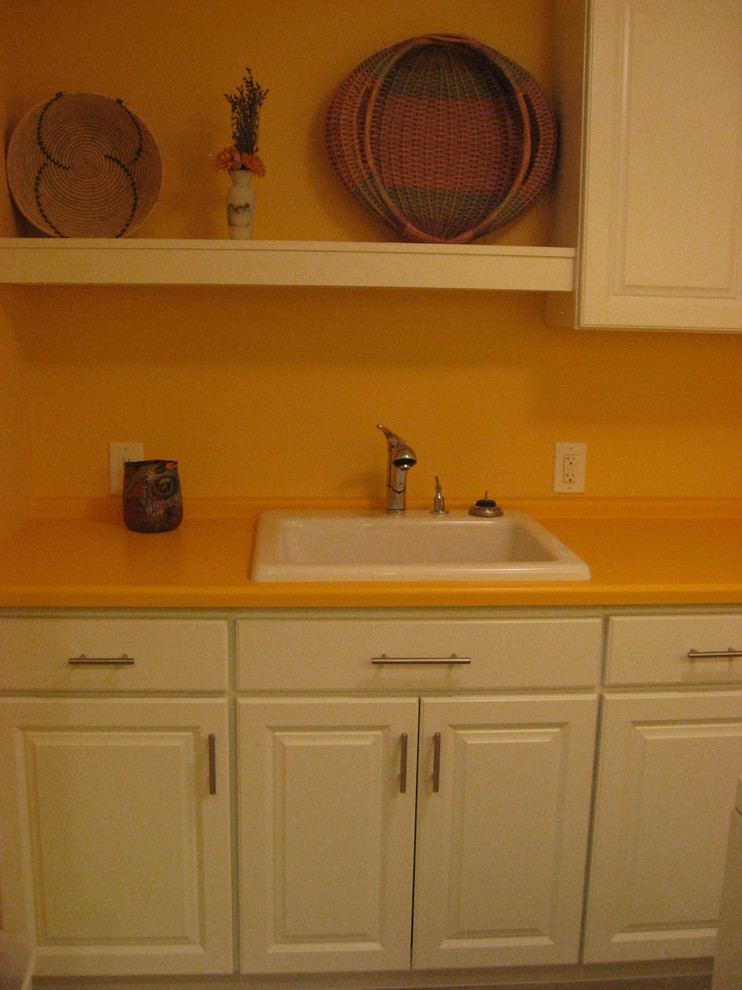 Example of a small eclectic galley ceramic tile dedicated laundry room design in Denver with a single-bowl sink, raised-panel cabinets, white cabinets, laminate countertops, orange walls and a side-by-side washer/dryer