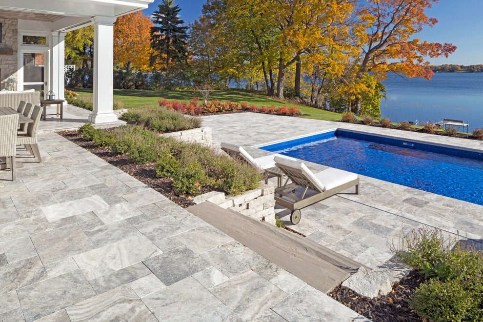 Inspiration for a beach style backyard rectangular pool in Minneapolis with a pool house and natural stone pavers.