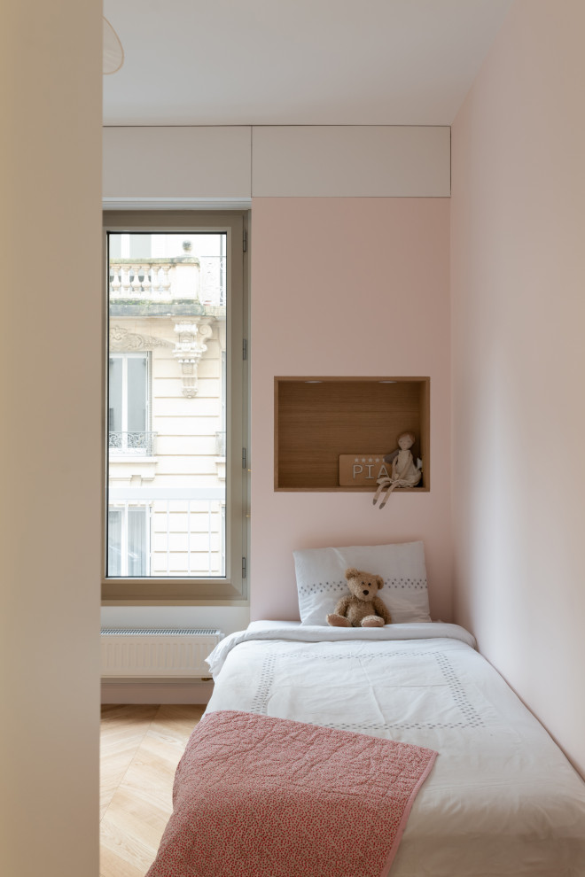 Bild på ett stort funkis flickrum kombinerat med sovrum och för 4-10-åringar, med rosa väggar, ljust trägolv och brunt golv