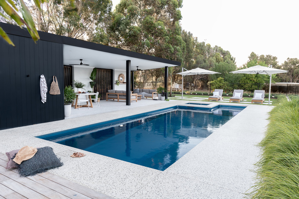 Ispirazione per una grande piscina design rettangolare dietro casa con una dépendance a bordo piscina