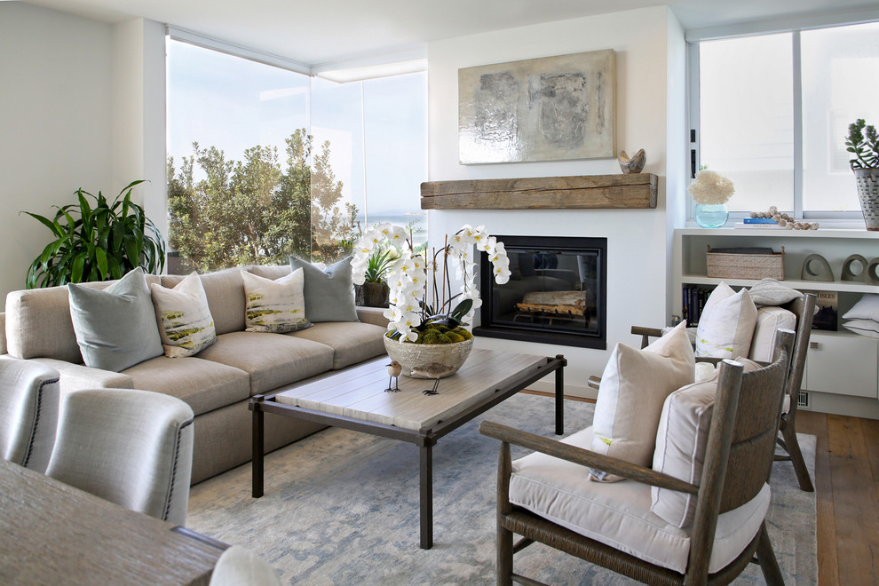 Photo of a mid-sized transitional formal open concept living room in Santa Barbara with white walls, dark hardwood floors, a standard fireplace, a plaster fireplace surround, no tv and brown floor.