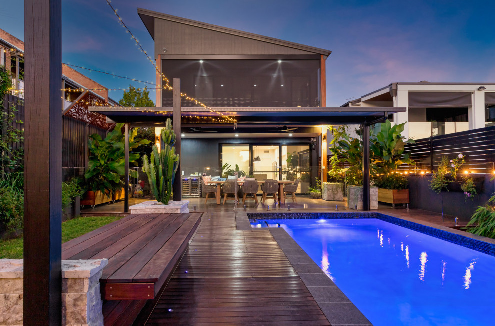 Kleiner, Halbschattiger Moderner Garten hinter dem Haus mit Hochbeet, Dielen und Metallzaun in Brisbane